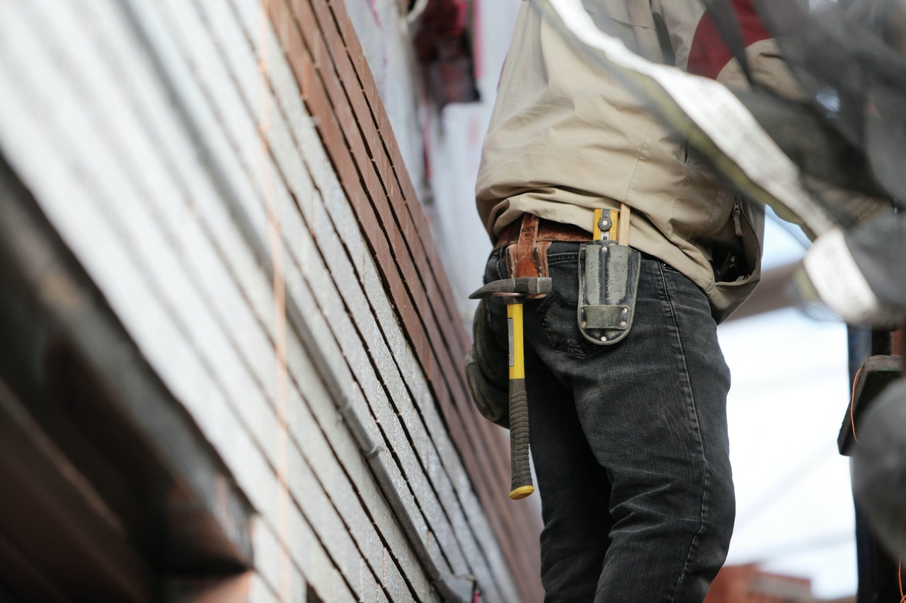 Tradesperson with tools, inspecting HVAC ductwork for cleaning and maintenance.