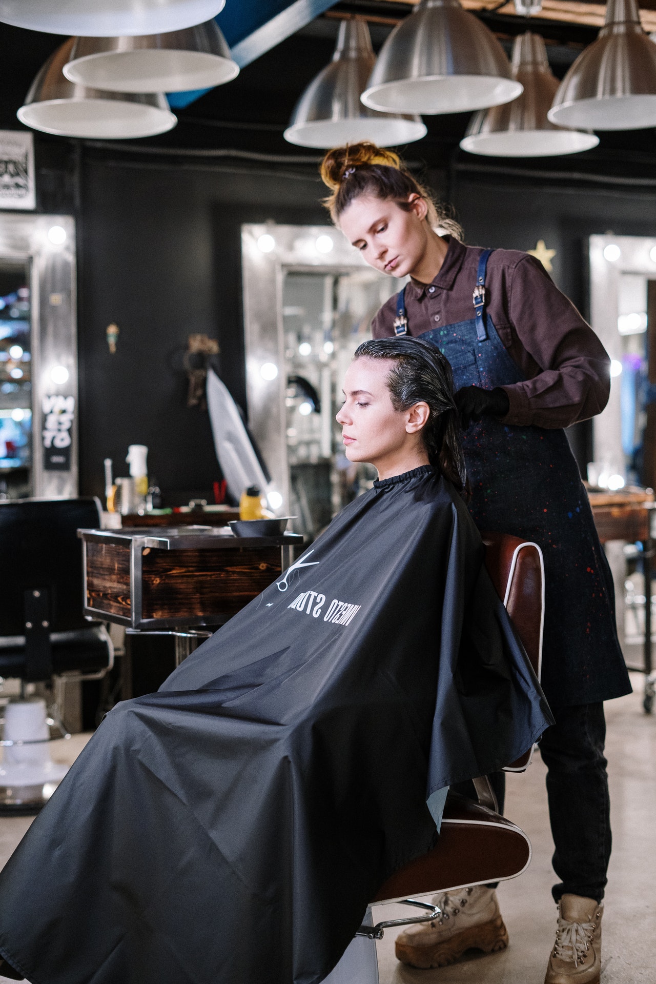 Hair stylist working on a client's hair in a modern salon, showcasing the beauty industry