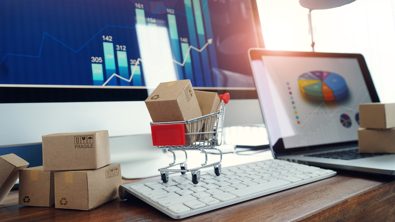 eCommerce business growth illustrated with charts, laptop, and shipping boxes in a shopping cart.